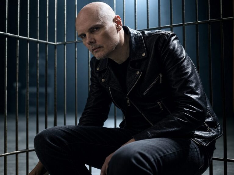 Billy Corgan seated behind prison bars in a black leather jacket, symbolizing the emotional cage and protective armor explored in the essay.